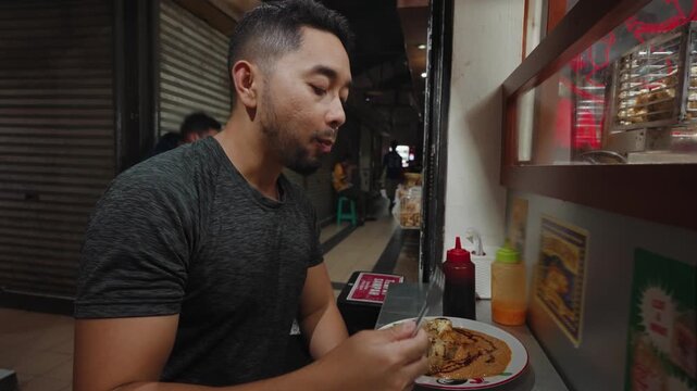 Traditional Indonesian batagor being fried, prepared, served with peanut sauce, and eaten at a local street food stall in Bandung. Authentic culinary scene showcasing popular West Java snack culture