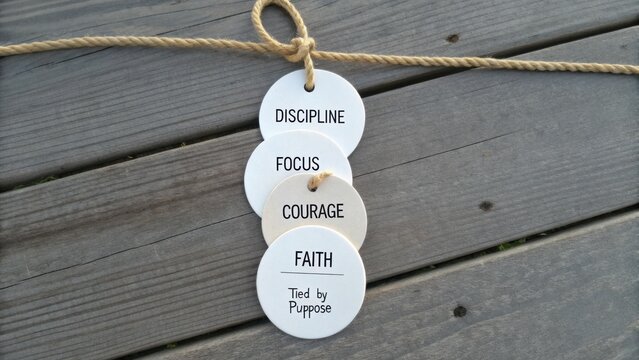 Inspirational Discs Representing Key Values such as Discipline, Focus, Courage, Faith, Tied Together with a Twine Rope