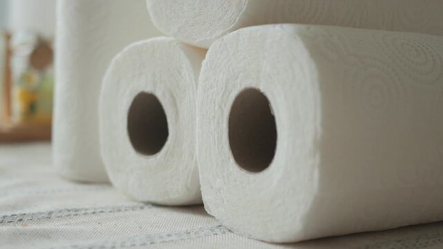 Stack of white paper towel rolls on a textured surface indoors closeup.