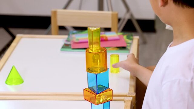 Child Dismantling Colorful Building Block Tower in Classroom