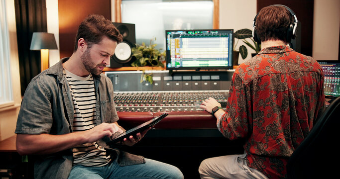 Sound engineer, tablet and man in recording studio for music, composition or song quality with team. Collaboration, mixing audio or editing with tech for equalizer, creative production and mastering