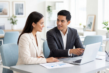 Fototapeta premium Two business professionals discussing project on laptop in office