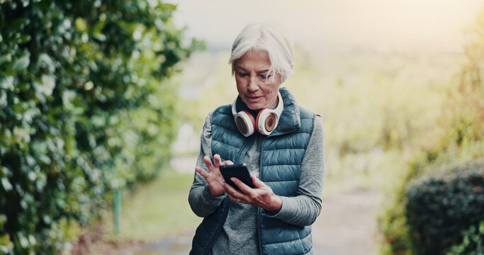 Outdoor, reading or old woman with phone for fitness, running route research or find training playlist. Park, workout app or senior person with tech for trail navigation, steps count or music search