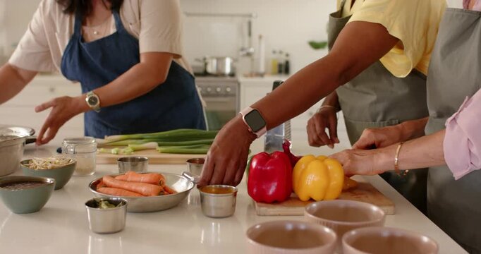 Diverse women following tablet recipe, chopping bell peppers on cutting board and grating carrots