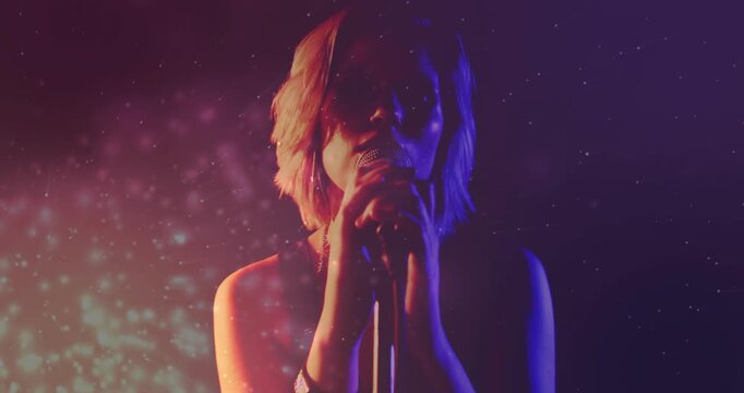 Female singer adjusting grip, bringing mic to mouth, starting song with warm left bokeh around face