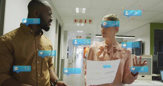 Two coworkers reviewing charts in marketing corridor, initiating like bubbles rising while walking
