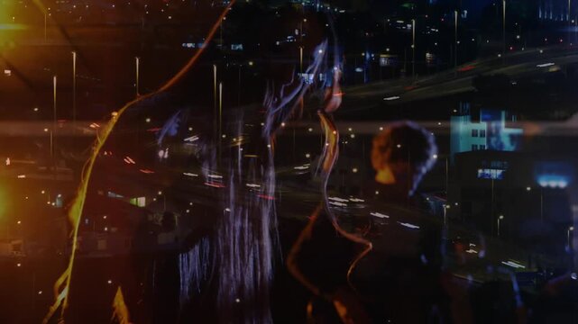 Lead musician leaning keys, playing synth while light cue starting city streaks over band for music