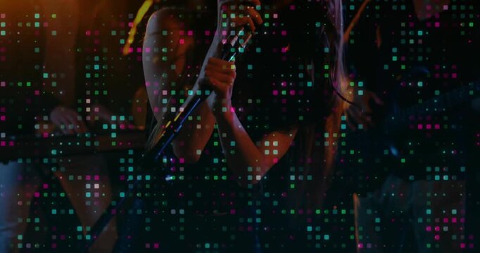 Vertical video: Lead singer gripping retro mic, tilting and singing music as pixel mosaic pulsing