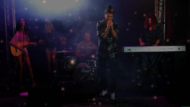 Singing lead singer holding mic, lifting head reaching louder passage as light flaring on stage