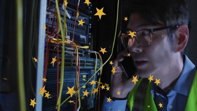 Technician receiving call, holding phone, leaning toward rack, inspecting cables, fixing connection