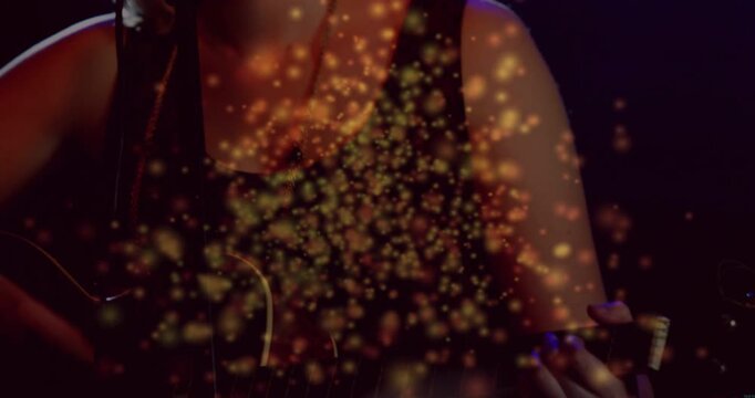 Teen musician starting strumming, singing for gig, gold sparks rising over guitar as cam tilting up