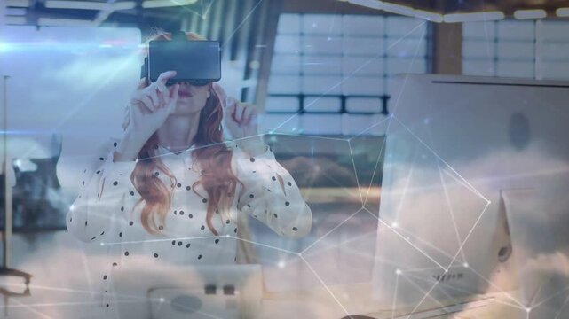 Vertical video: After visor lowering woman wearing VR headset white blouse selecting nodes at desk