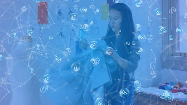 Woman reaching down, unfolding jacket in design studio, blue filter showing money nodes for hanging