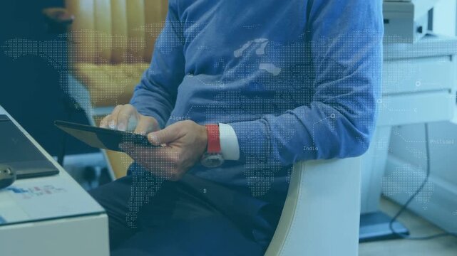 Vertical video: Reacting to map overlay, man in blue sweater tapping and tilting tablet at desk