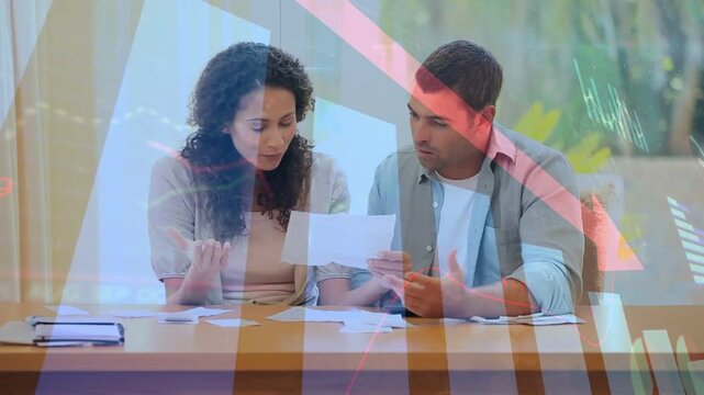 Couple opening mail, sorting bills and paying via phone, semi-transparent finance charts overlaying