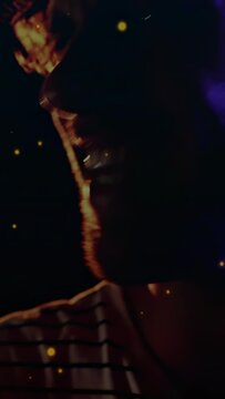 Vertical video: Microphone entering frame, singer leaning and singing, purple light for performance