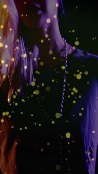 Vertical video: Pressing keys starting gold dots, woman playing keyboard, tilting and flipping hair