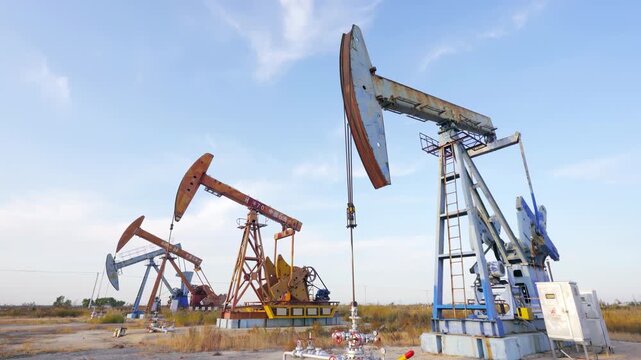 Crude oil pump jack operates from ground desert oilfield sunrise industrial landscape, oil drill rig, drilling derrick in oilfield. Crude petroleum industry creating energy anticipation and pump rigs