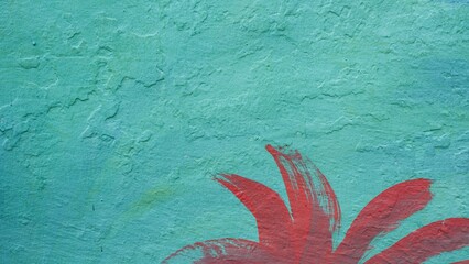 A close-up shot of a weathered turquoise cement wall featuring a red hand-painted floral motif. This distressed surface provides a unique artistic background for urban design. © agung