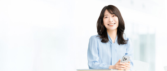 スマートフォンを持つ日本人女性・ビジネスウーマンのビジネスイメージ（LP・バナー向け）, Japanese Businesswoman Holding Smartphone for Landing Page Banner © Trickster*
