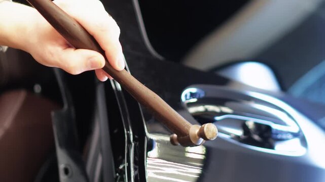 Body repair. A specialist repairs a dent on the car body without painting. Paintless Car Dent Repair. PDR. Process of paintless dent repair on car body. The mechanic at the auto shop with tools. 