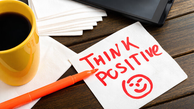 A note says &ldquo;Think Positive&rdquo; on a desk.