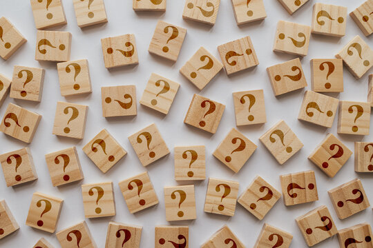 A large collection of wooden tiles with too many question marks. The shallow depth of field emphasizes sea of inquiries and ideas