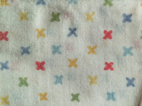 Textura de tela blanca con patr&oacute;n de peque&ntilde;as cruces de colores variados