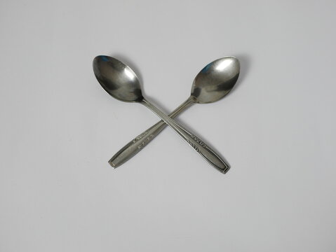 two tablespoons stacked on a white background