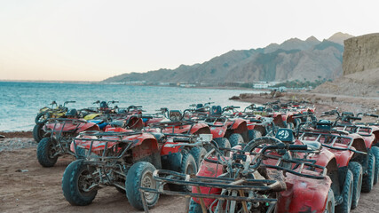 Riding A ATV quadbike vehicles enjoy a summer adventure on the sandy beach near the ocean under a clear sky © Syaifur Rohman