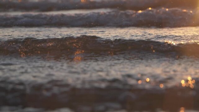 Red sunrise sea waves close up, shallow dof