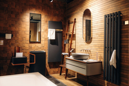 Modern bathroom interior featuring wooden wall tiles, stylish sink, mirror, and towel rack with contemporary design elements and warm lighting