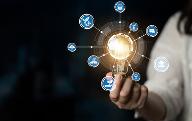 Fototapeta premium A creative representation of a glowing lightbulb surrounded by various icons, symbolizing innovation and technological advancement in a modern environment. Crux