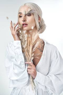 Think, beauty or woman with wheat in studio for creative art, natural or organic on white background. Plants, cosmetic or serious person with eco friendly skincare, bunny tail grass or reflection