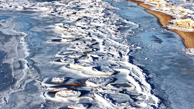Ice floes covering water with frozen banks during cold winter season