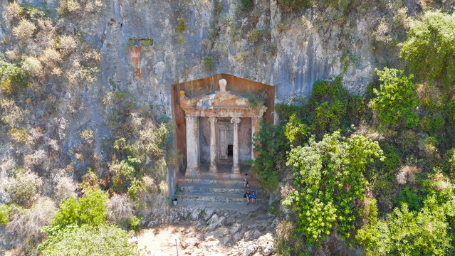 Fethiye, Turkey. Magnificent Tomb of Amyntas and ancient Lycian rock cut tombs carved into the mountain cliffs on a sunny summer day, aerial drone view.. Aerial View