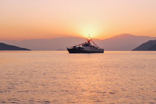 Turkish naval ship dressed with signal flags at sunrise in the bay
