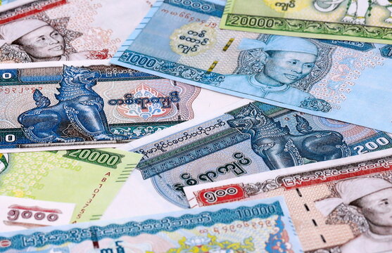 Myanmar kyat money bills pile on table. Myanmar banknotes of MMK currency close up.