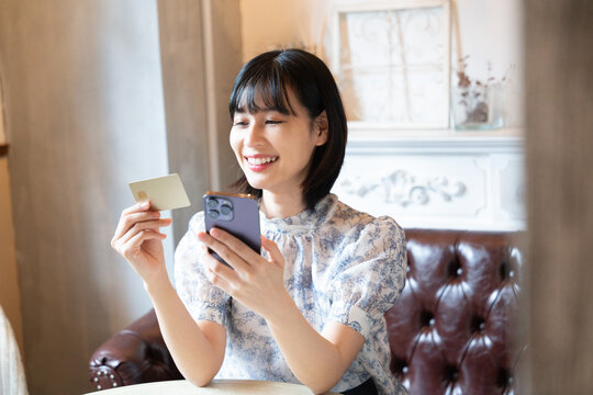 スマホをでカードで決済をしようとしている女性