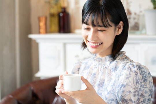 カフェでコーヒーを飲みながらリラックスしている女性