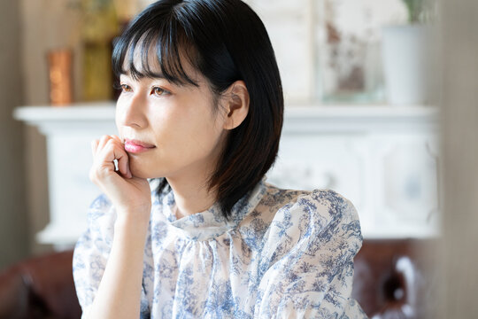 カフェで頬杖をついている女性