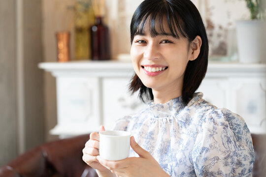 カフェでコーヒーを飲みながらリラックスしている女性