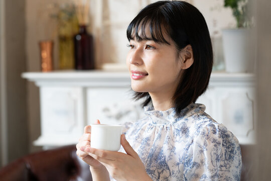 カフェでコーヒーを飲みながらリラックスしている女性