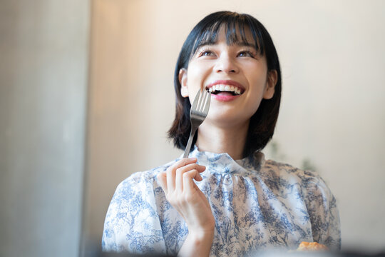 フォークを持って嬉しそうな表情をしている女性