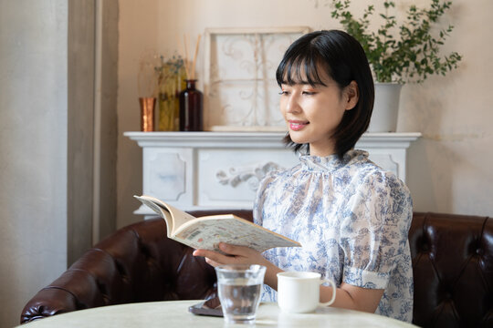 カフェで本を読みながらリラックスしている女性