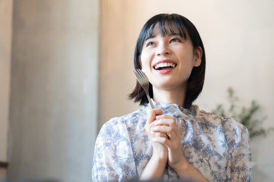 フォークを持って嬉しそうな表情をしている女性