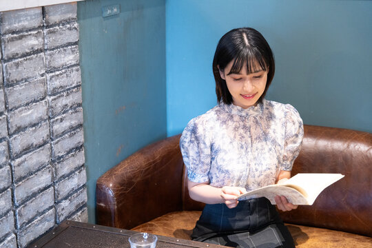 カフェで本を読んでいる女性