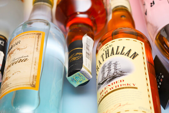 Lviv, Ukraine - March 25, 2026: An assortment of premium alcoholic beverages in glass bottles featuring whisky, vodka, and traditional Portuguese aguardente. 