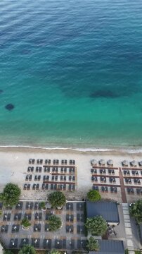 Cinematic shot of Barbati Beach and the Ionian Sea in Corfu, Greece. High-quality 4K landscape featuring emerald water, rocky shore, and lush green hills of the Mediterranean coast.