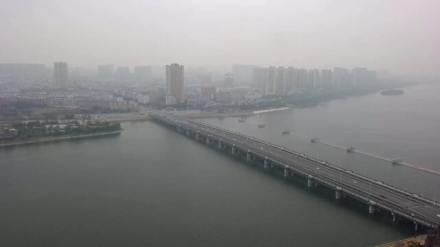 A dynamic 1080p moving aerial hyperlapse traveling over a complex multi-level highway interchange in Wuhan, China, capturing the fast-paced flow of traffic.